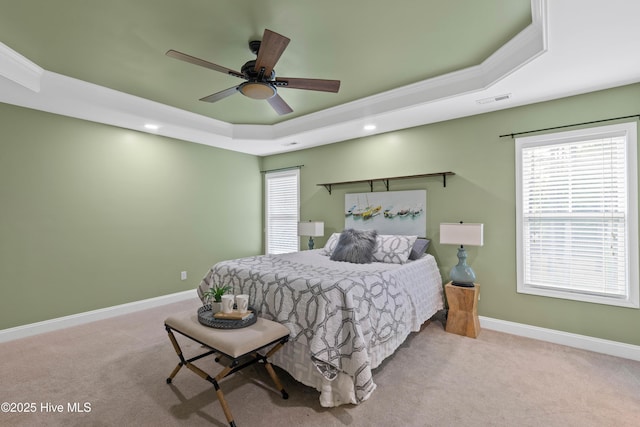 carpeted bedroom featuring a raised ceiling, ceiling fan, and crown molding