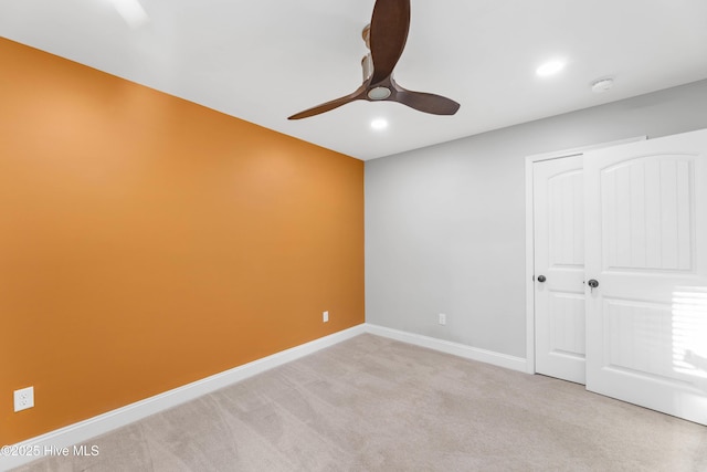 unfurnished bedroom featuring ceiling fan and light carpet