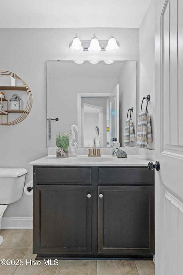 bathroom with tile patterned flooring, vanity, and toilet