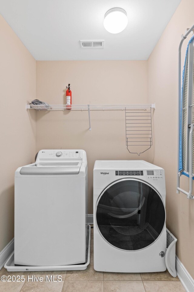 washroom featuring light tile patterned floors and washer and clothes dryer