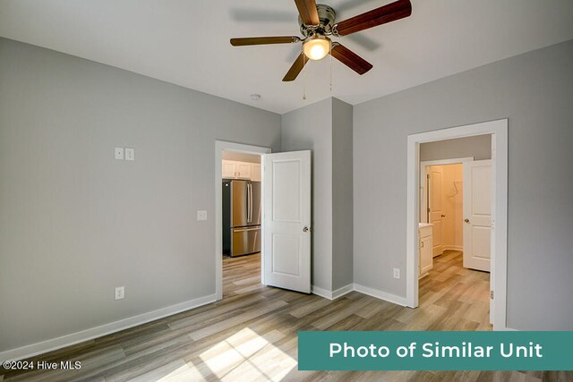 unfurnished bedroom featuring baseboards, light wood-type flooring, a ceiling fan, and freestanding refrigerator