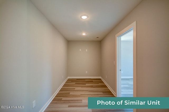 empty room featuring baseboards, recessed lighting, and light wood-style flooring