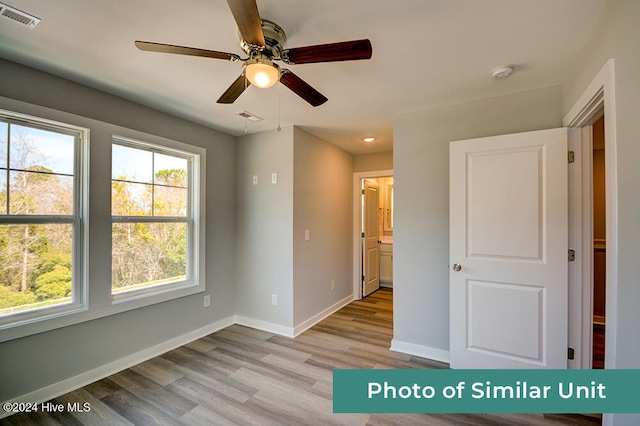unfurnished room featuring light wood finished floors, visible vents, ceiling fan, and baseboards