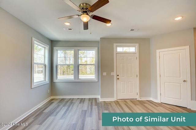 foyer featuring visible vents, baseboards, a ceiling fan, and light wood-style floors