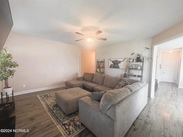 living room with dark wood-type flooring and ceiling fan