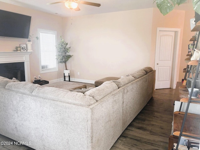 living room featuring dark wood-type flooring and ceiling fan