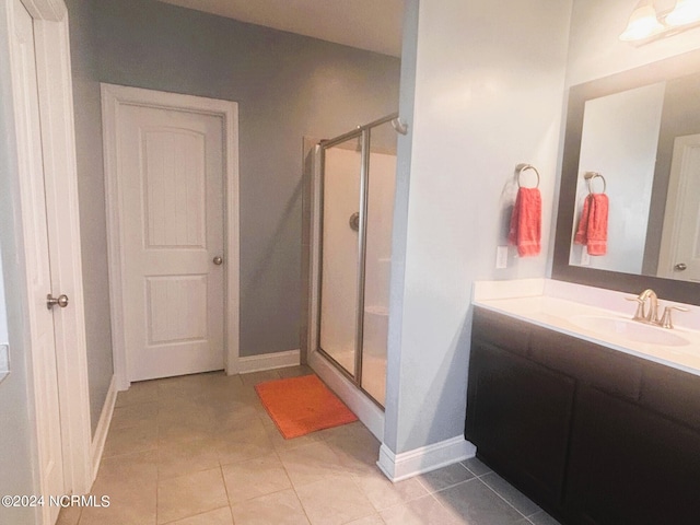 bathroom with vanity, a shower with door, and tile patterned floors