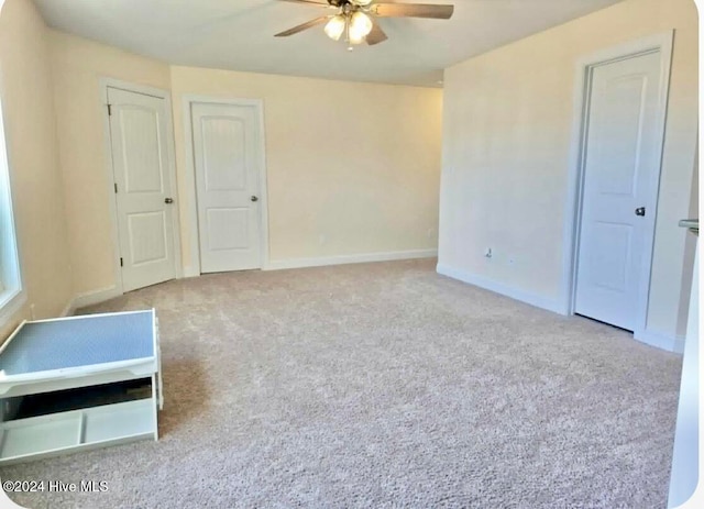 empty room featuring ceiling fan and light colored carpet