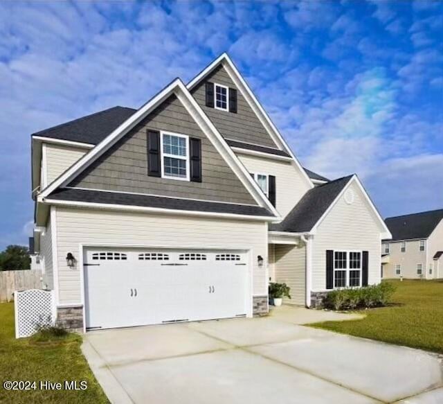 craftsman house featuring a front lawn and a garage