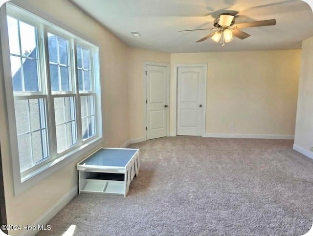 unfurnished room with light carpet and ceiling fan