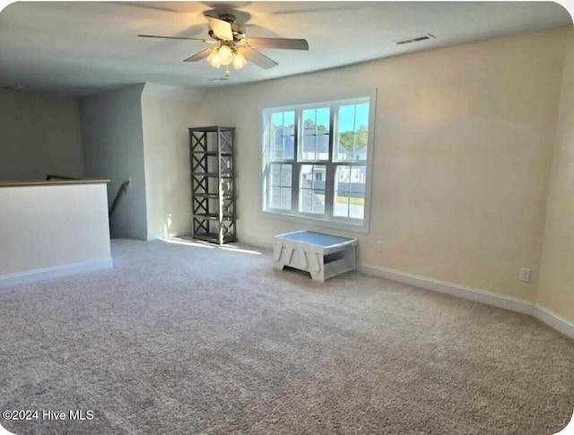 carpeted spare room with ceiling fan