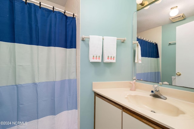 bathroom with vanity, a textured ceiling, and a shower with curtain