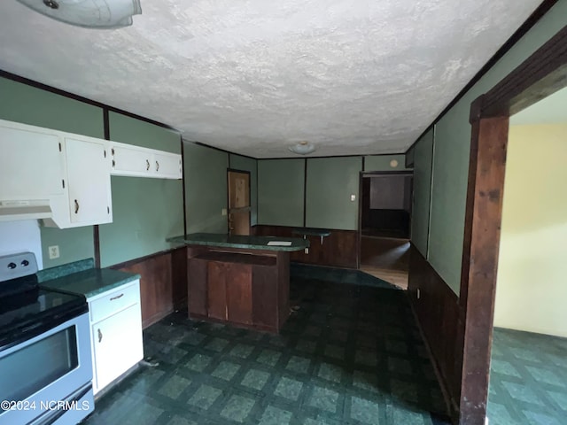 kitchen featuring a textured ceiling, wood walls, white cabinetry, exhaust hood, and white range with electric stovetop