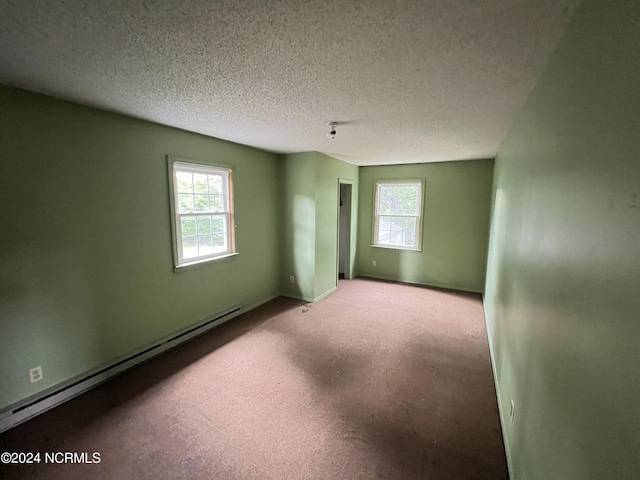 205 E Pinewood St, Roseboro, NC 28382 - empty room featuring a textured ceiling, a baseboard heating unit, baseboards, and carpet