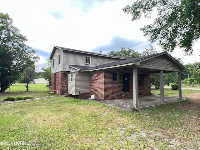 back of house with a lawn and a patio area