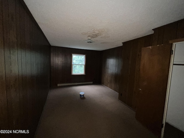 205 E Pinewood St, Roseboro, NC 28382 - unfurnished room featuring wood walls, a baseboard radiator, and carpet