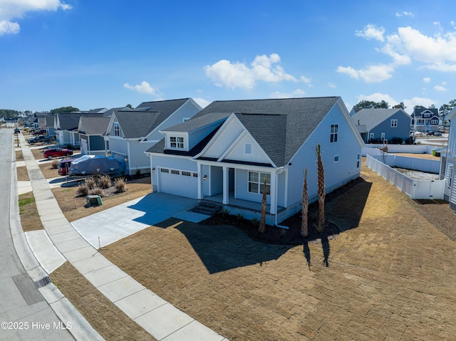 view of front of property with a porch, a garage, fence, driveway, and a residential view