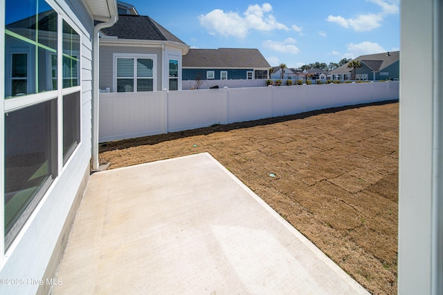 view of yard featuring a residential view, fence, and a patio