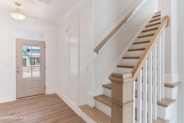 entryway with visible vents, stairway, and light wood finished floors