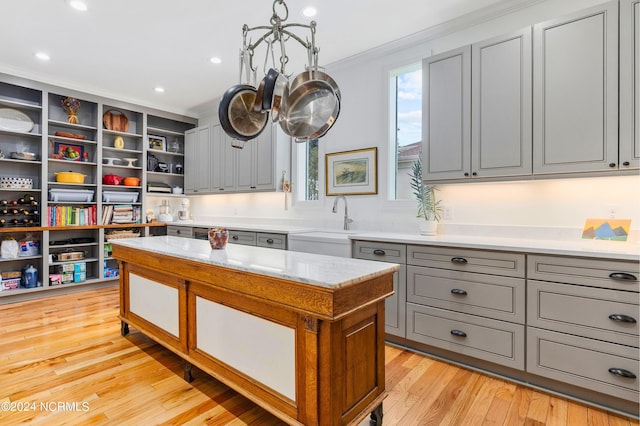 1324 Harbour Watch SW, Calabash, NC 28467 - kitchen with gray cabinetry, open shelves, a sink, light wood-type flooring, and ornamental molding