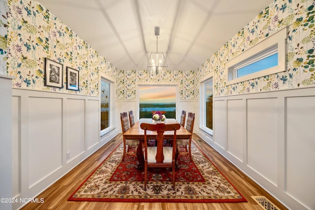 1324 Harbour Watch SW, Calabash, NC 28467 - dining room featuring wallpapered walls, a chandelier, wood finished floors, wainscoting, and a decorative wall