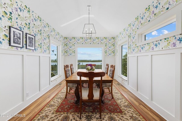 1324 Harbour Watch SW, Calabash, NC 28467 - dining room with wallpapered walls, a chandelier, a wainscoted wall, light wood-style floors, and a decorative wall
