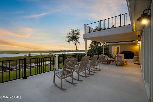 1324 Harbour Watch SW, Calabash, NC 28467 - patio terrace at dusk with a balcony, a water view, and outdoor lounge area
