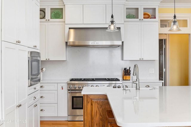 1324 Harbour Watch SW, Calabash, NC 28467 - kitchen with high end stainless steel range, wall chimney exhaust hood, light countertops, and decorative light fixtures