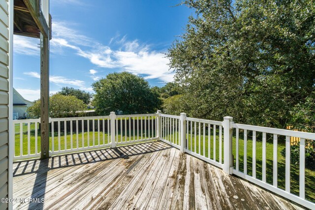 wooden deck featuring a lawn