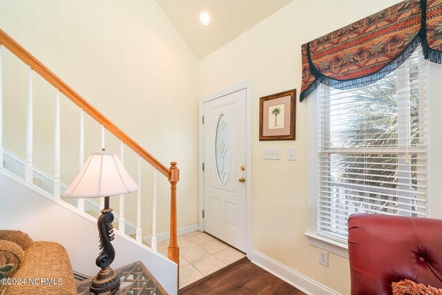 foyer entrance with lofted ceiling and hardwood / wood-style floors