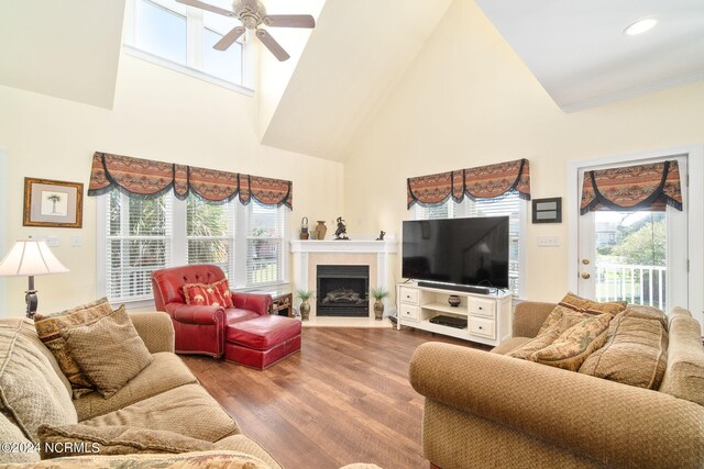 living room with high vaulted ceiling, ceiling fan, and hardwood / wood-style flooring