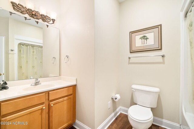 bathroom featuring walk in shower, vanity, and toilet