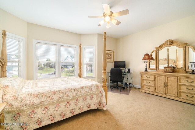 bedroom featuring light carpet, multiple windows, and ceiling fan