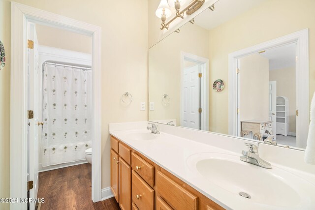 bathroom with wood-type flooring, vanity, toilet, and a shower with shower curtain