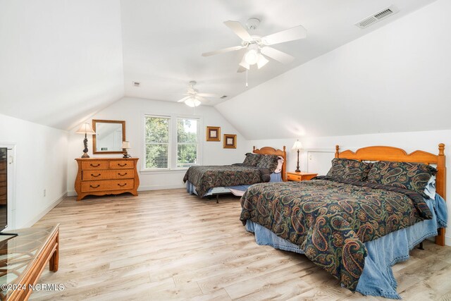 bedroom featuring light wood-type flooring, lofted ceiling, and ceiling fan