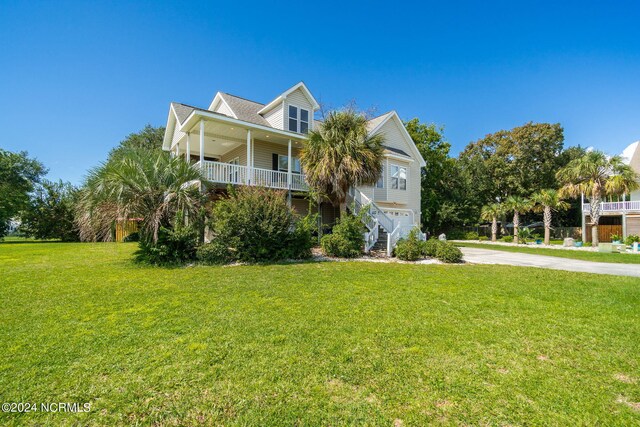 coastal inspired home with a front lawn and a porch