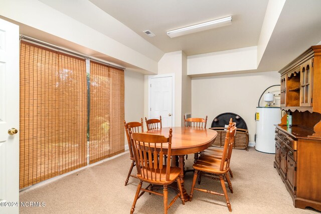 dining room with light carpet and water heater