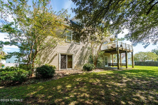 rear view of property with a wooden deck and a yard