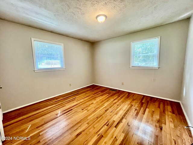 full bathroom featuring toilet, vanity, a textured ceiling, and washtub / shower combination