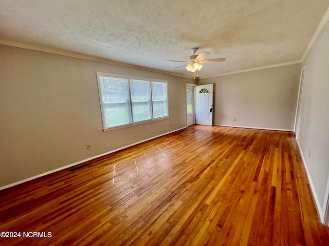 empty room with a textured ceiling, light hardwood / wood-style floors, ceiling fan, and ornamental molding