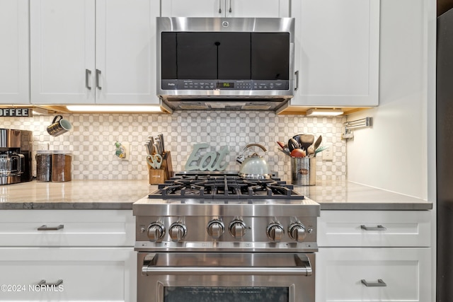 kitchen with backsplash, white cabinetry, light stone counters, and appliances with stainless steel finishes