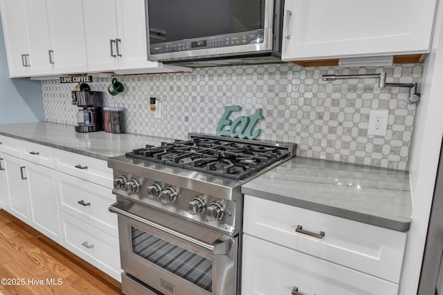 910 Old Dow Rd, Carolina Beach, NC 28428 - kitchen with stainless steel appliances, white cabinetry, light stone countertops, and tasteful backsplash