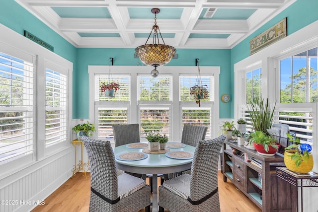 910 Old Dow Rd, Carolina Beach, NC 28428 - dining room featuring light wood-style flooring, coffered ceiling, beam ceiling, a wainscoted wall, and crown molding