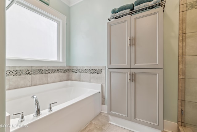 bathroom with tile patterned flooring and a bath