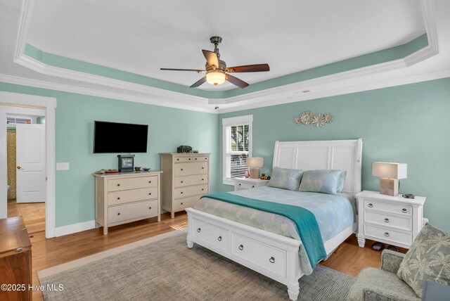 910 Old Dow Rd, Carolina Beach, NC 28428 - bedroom featuring a tray ceiling, wood finished floors, ornamental molding, and ceiling fan
