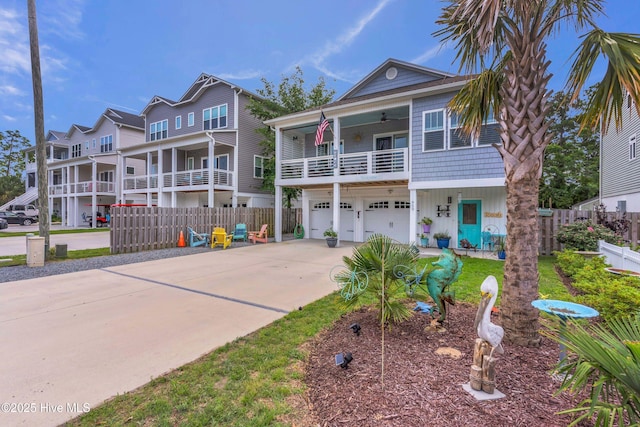 910 Old Dow Rd, Carolina Beach, NC 28428 - view of front of house featuring concrete driveway, a balcony, an attached garage, and a ceiling fan