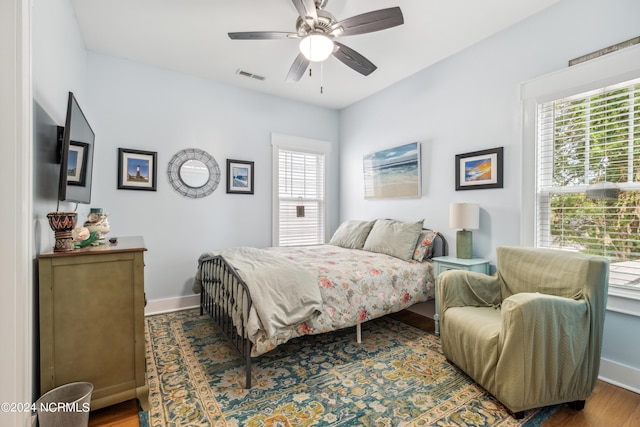 bedroom featuring multiple windows, ceiling fan, and dark wood-type flooring