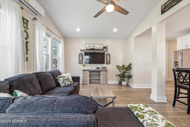 living room with ceiling fan, vaulted ceiling, light wood-type flooring, and a wall mounted AC