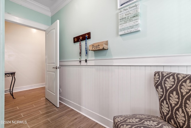 hallway with wood-type flooring and crown molding