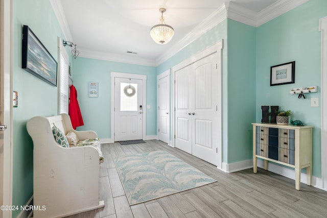 entryway with a chandelier and ornamental molding